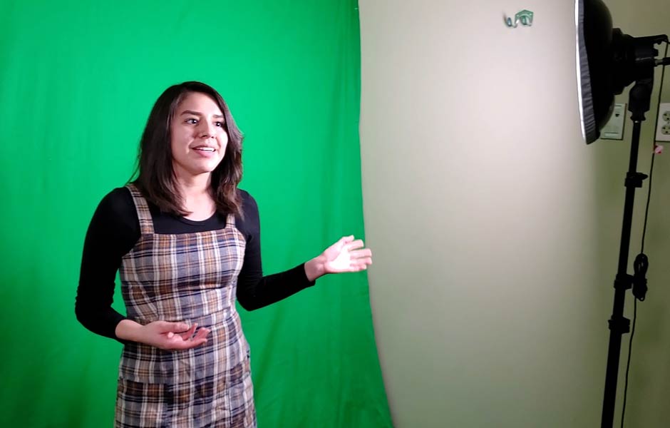 student standing in front of green screen