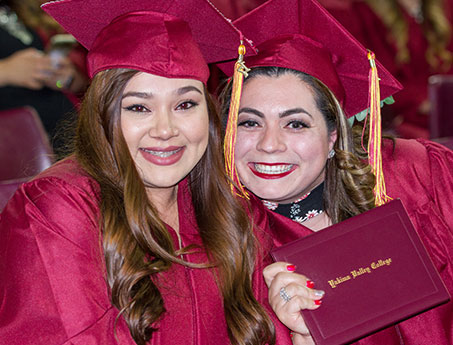 two smiling students at commencement