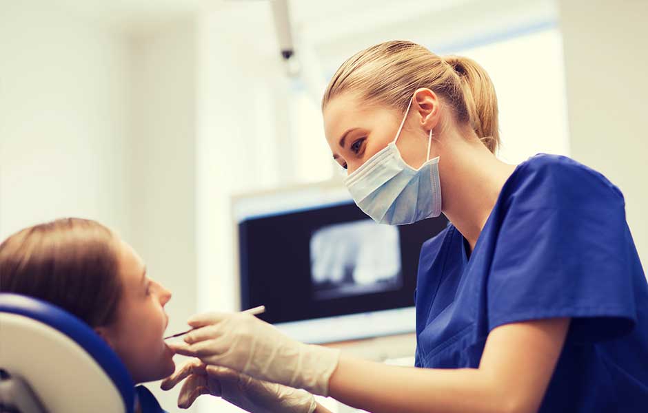 Female dental assistant working on young girl