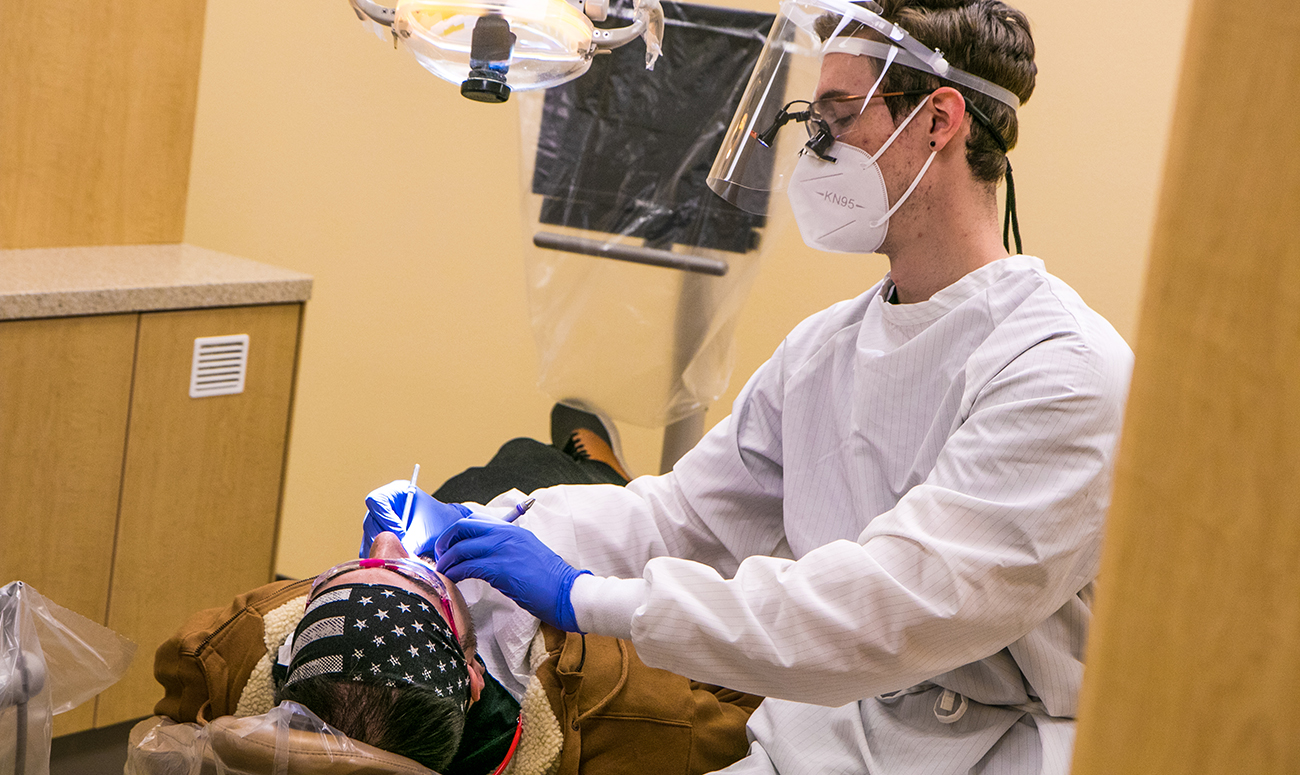 Dental Hygiene student works on a patient
