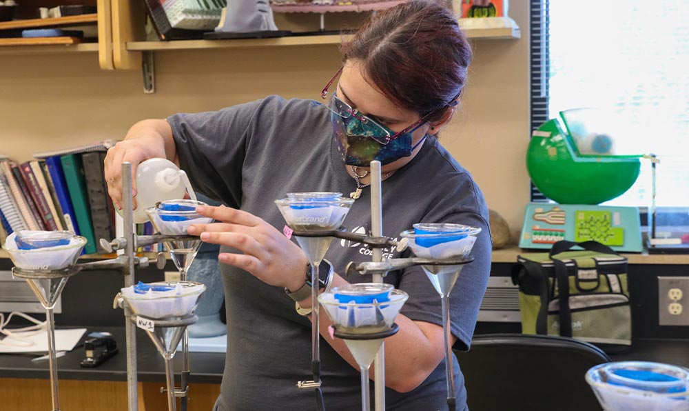Student sets up beakers in chemistry lab