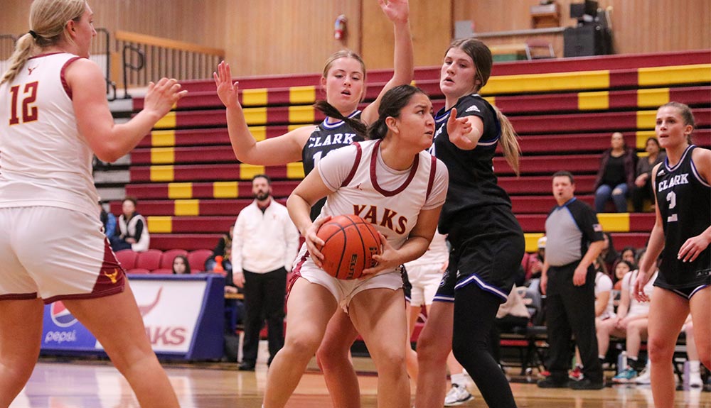 Women's basketball player in post against two defenders