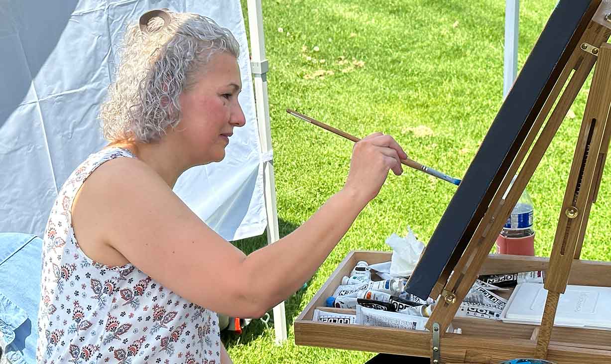 An artist paints during the 2023 Fresh Air Art Celebration
