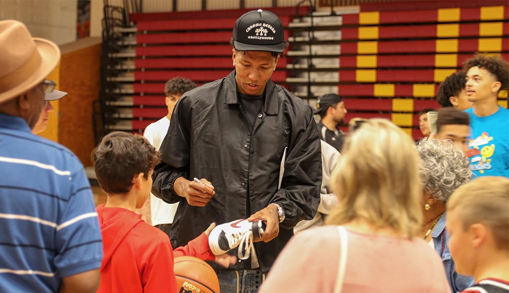 Basketball player signs fan's shoe