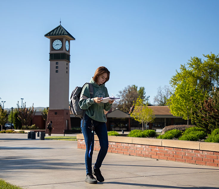 Female student walks by clocktower