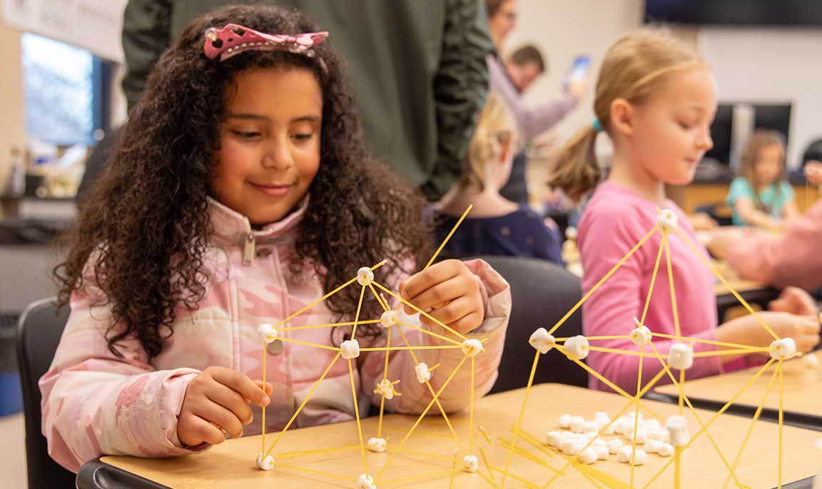 7-year-old Cheli Rodriguez builds a structure using marshmallows and spaghetti noodles during the 2024 STEM Day.