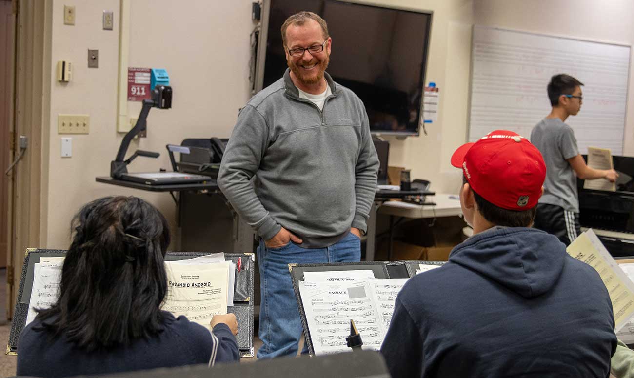 Jeffrey Smith talks with students during class