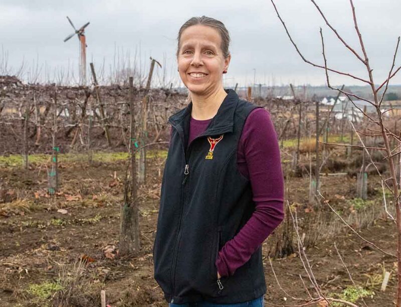 Stacey Gringas poses for a photo in her orchard in Benton City, Wash.