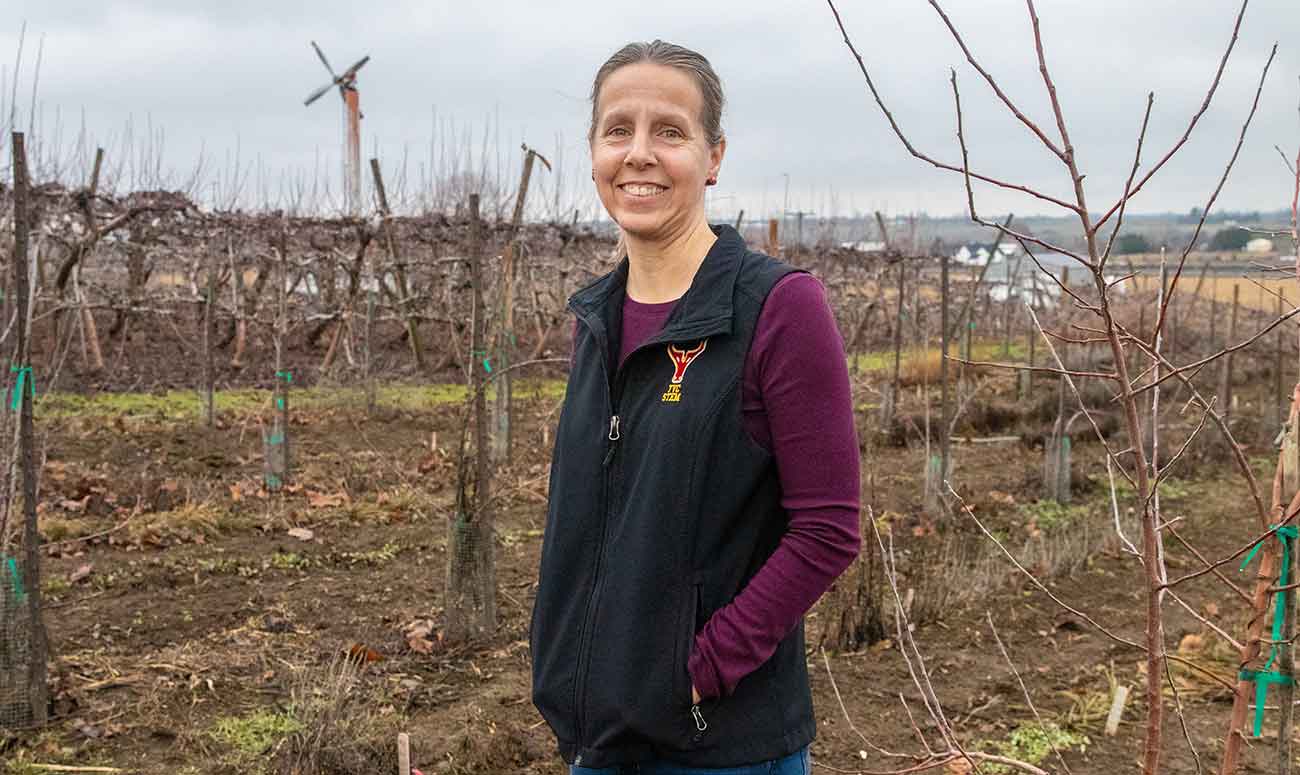 Stacey Gringas poses for a photo in her orchard in Benton City, Wash.