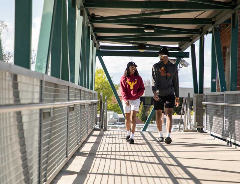 Students walk across the pedestrian bridge on YVC's Yakima Campus