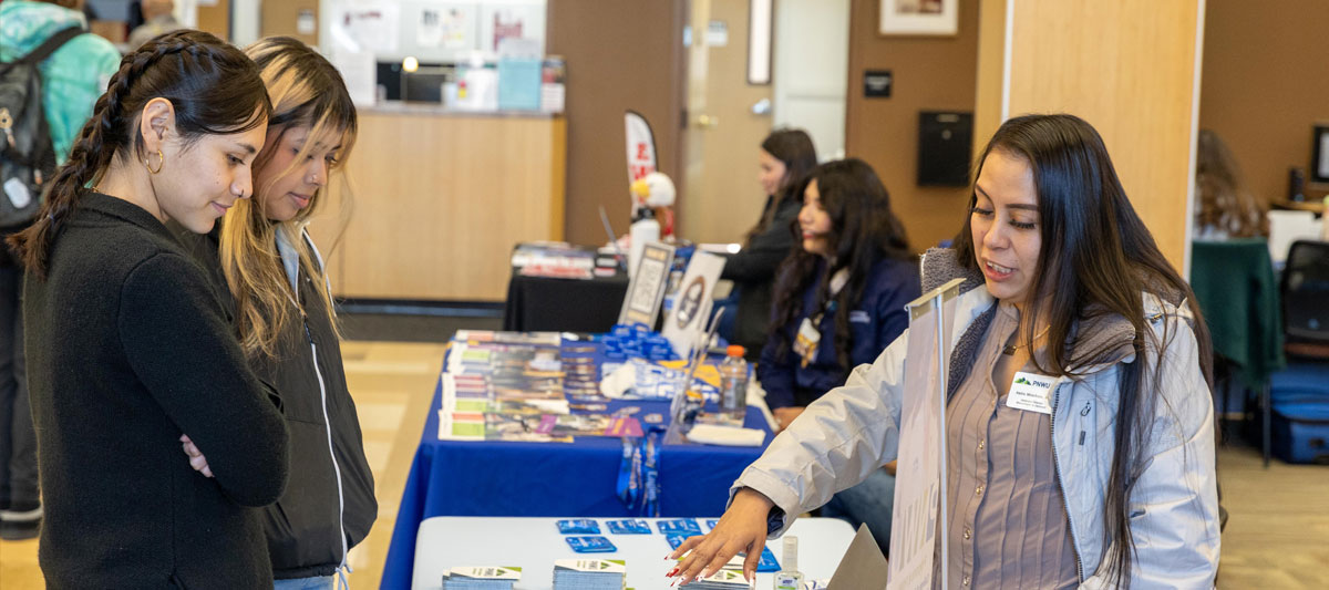 Representative speaks with YVC students during fair event. 