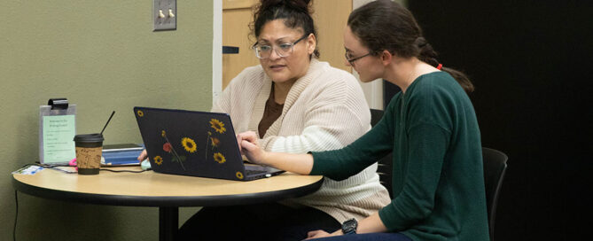 A student speaks with an instructor in the Writing Center on the Grandview Campus