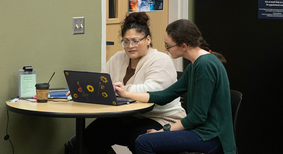 A student speaks with an instructor in the Writing Center on the Grandview Campus