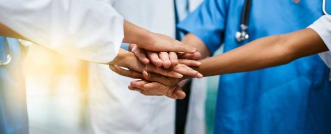 Doctor and nurses stacking hands close up