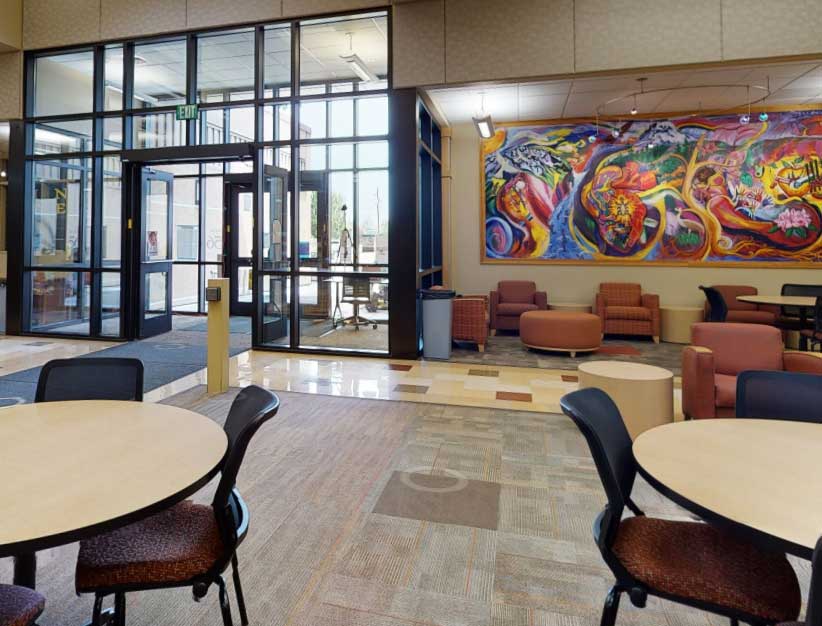 lobby doors and seating area. Colorful mural on the wal.
