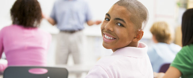 Young male student in class smiling