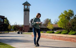 Student looks at notes while walking on the Yakima Campus
