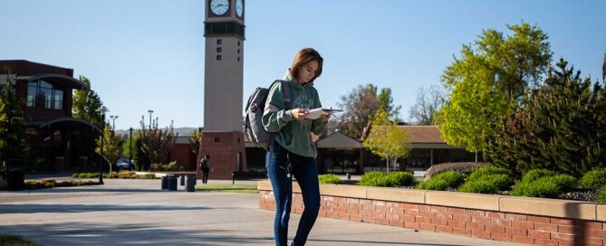 Student looks at notes while walking on the Yakima Campus