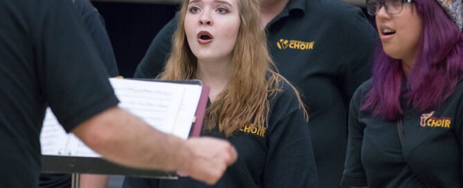 Choir members sing during high school tour