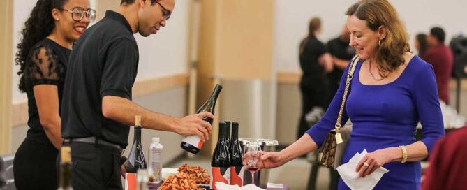Student winemaker pours wine during 2023 Grape to Glass Gala event